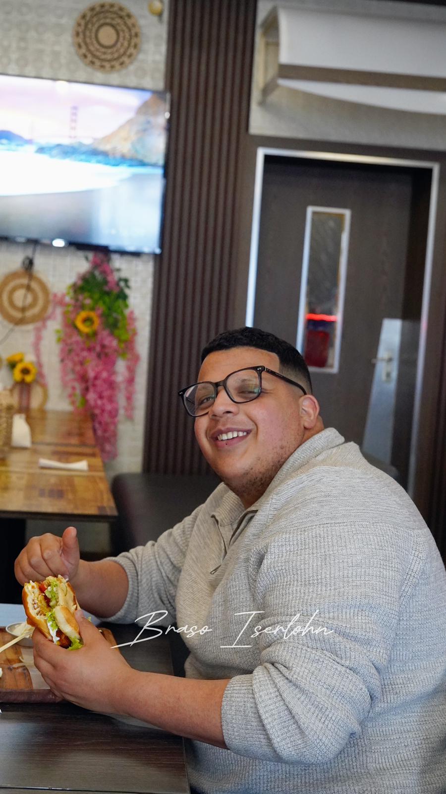 Kunde genießt einen Burger bei Braso